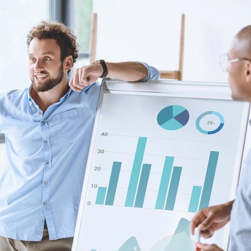 multiethnic-businessmen-standing-near-white-board--74GV65M